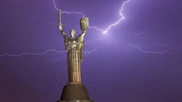 Темне небо з блискавками над міським пейзажем, що символізує грози в Київській області