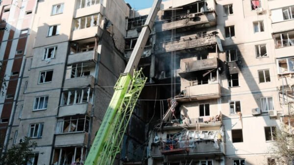 Зруйнований будинок у Києві, постраждалий від обстрілів, на тлі якого надається допомога киянам від обстрілів