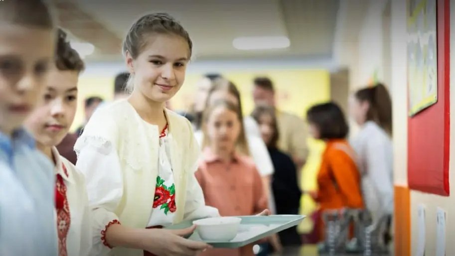 Школяр отримує гарячий обід у шкільній їдальні