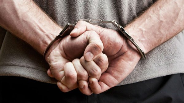 Поліцейські вилучають гроші у підозрюваного в шахрайстві